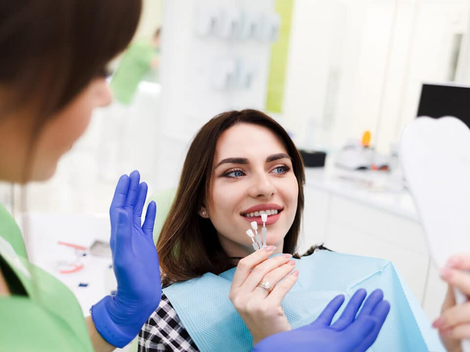 woman in the dentist chair is choosing out the colour of her new dental veneers