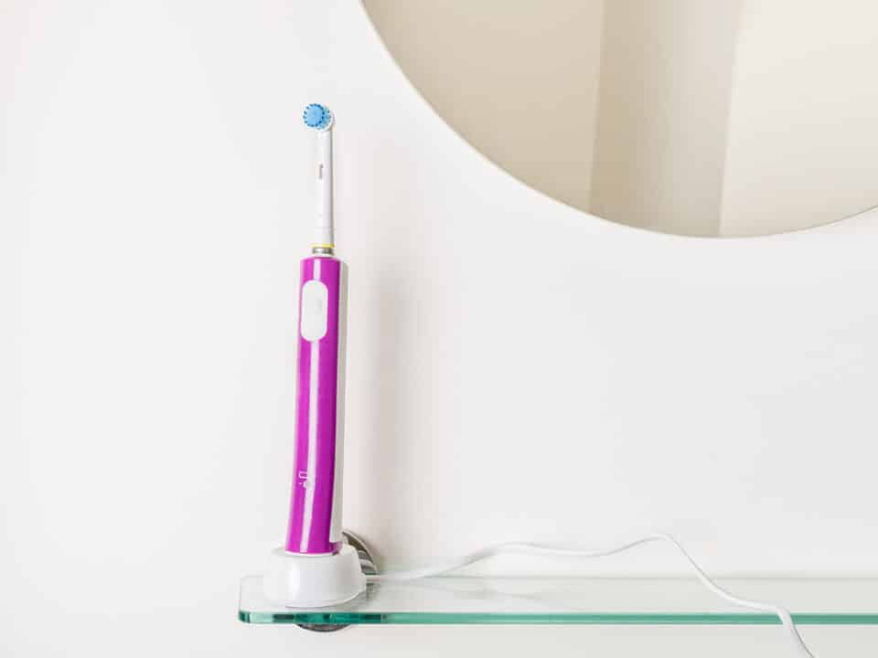 photo of an electric toothbrush standing in the bathroom