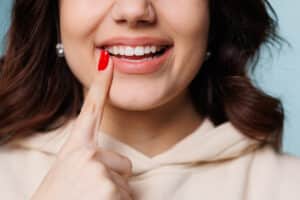 woman pointing to her amazing smile she got from a cosmetic dentist