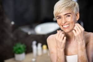woman with short blonde hair flosses as part of her new years resolutions for oral health care