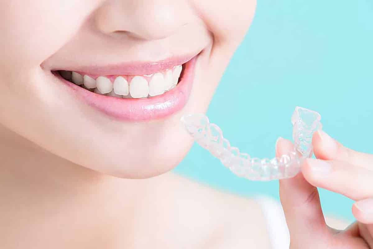 woman holding clear braces wondering to herself are clear braces effective?