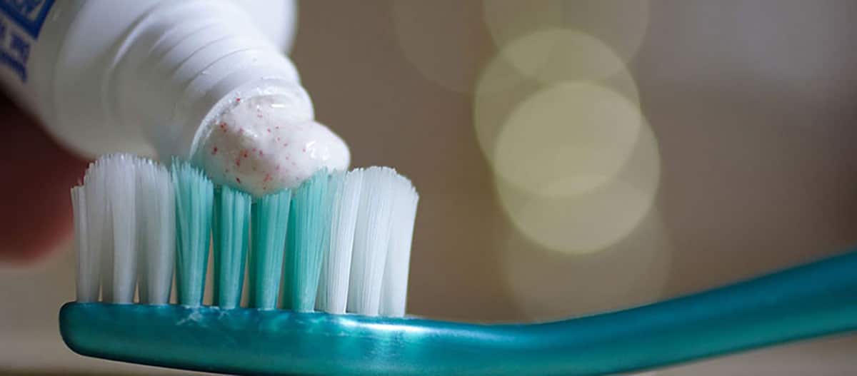 picture of a toothbrush with some whitening toothpaste being applied