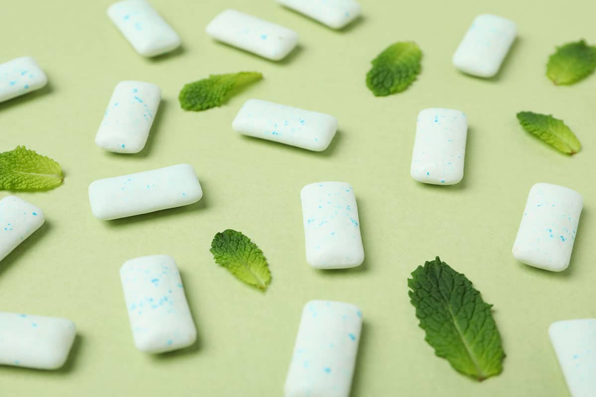 image of some sugar free gum and mint leaves on a light green background