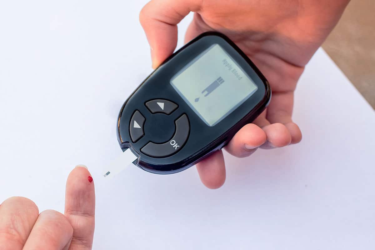photo of a diabetic testing their blood with a machine