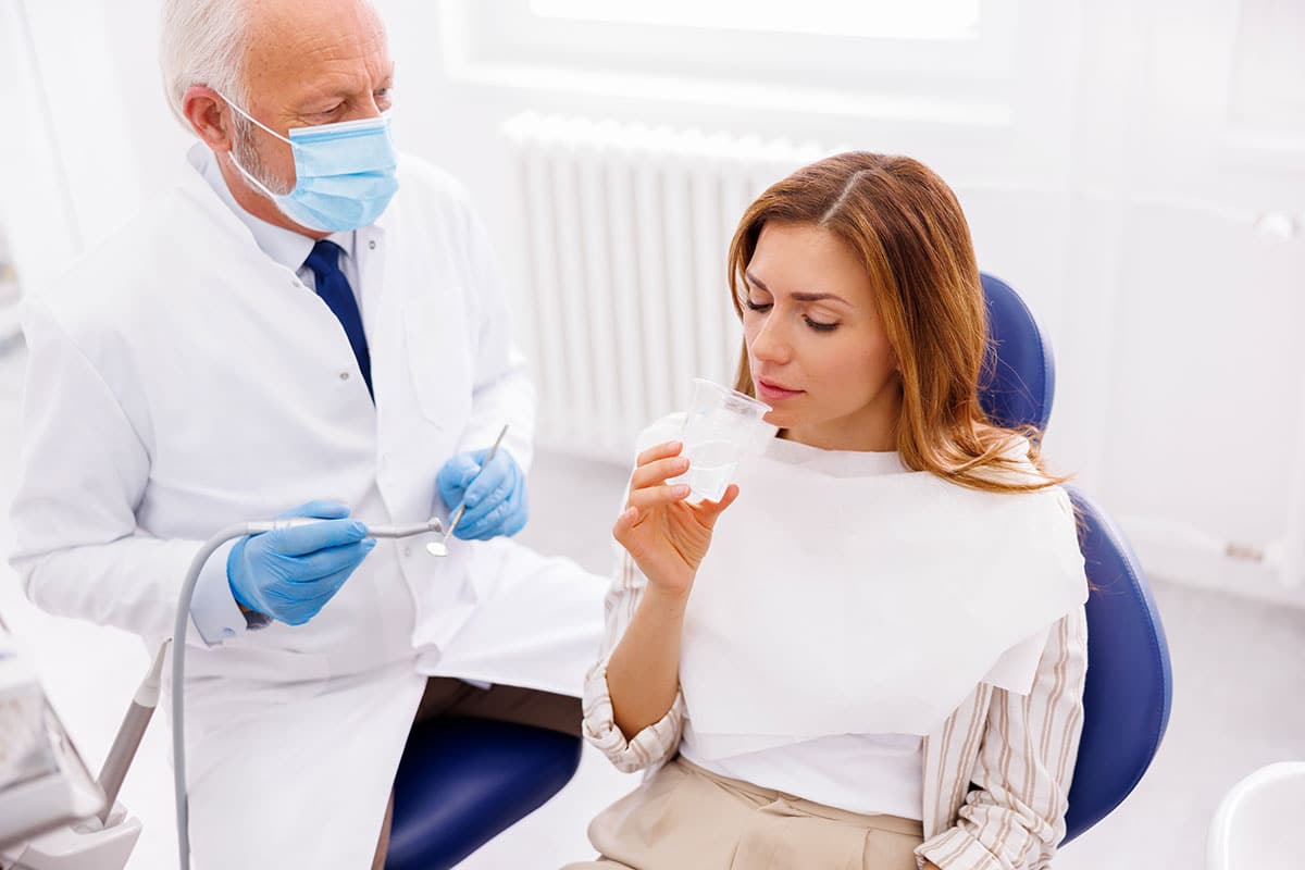 woman discussing the mouth-body connection with her dentist, learning how oral health affects your overall health