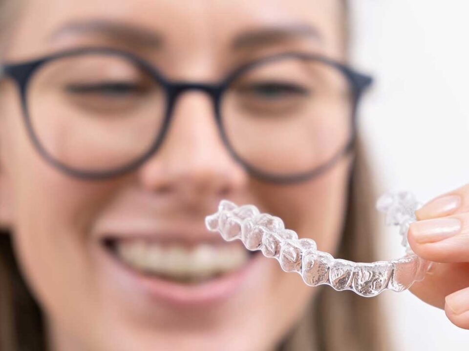 woman showing of her clear aligners after being asked what are clear aligners