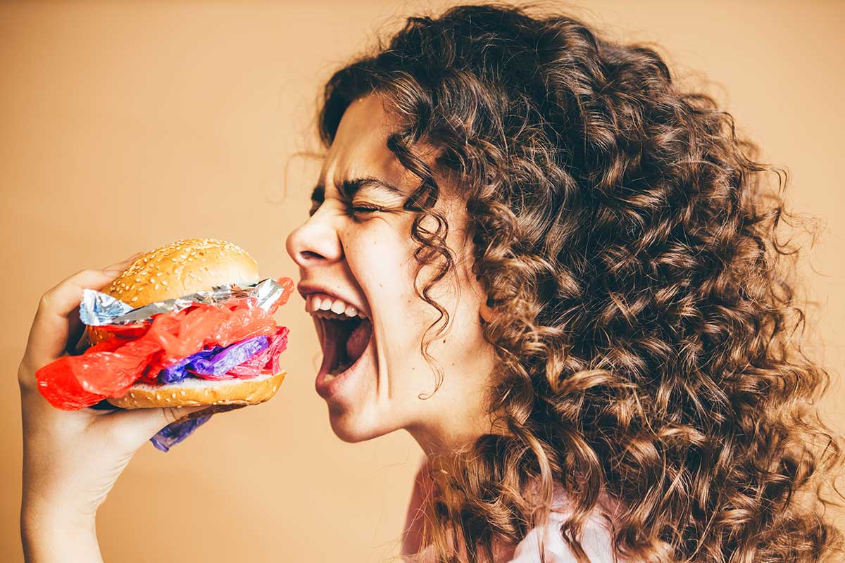woman about to bite into a huge burger