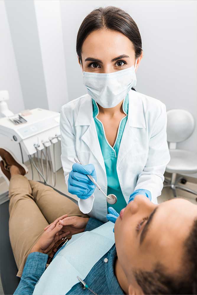 dentist performs a dental exam and cleaning appointment on her patient