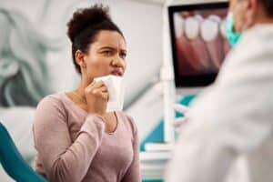 woman experiencing one of the most common dental issues (a toothache) is speaking to her dentist