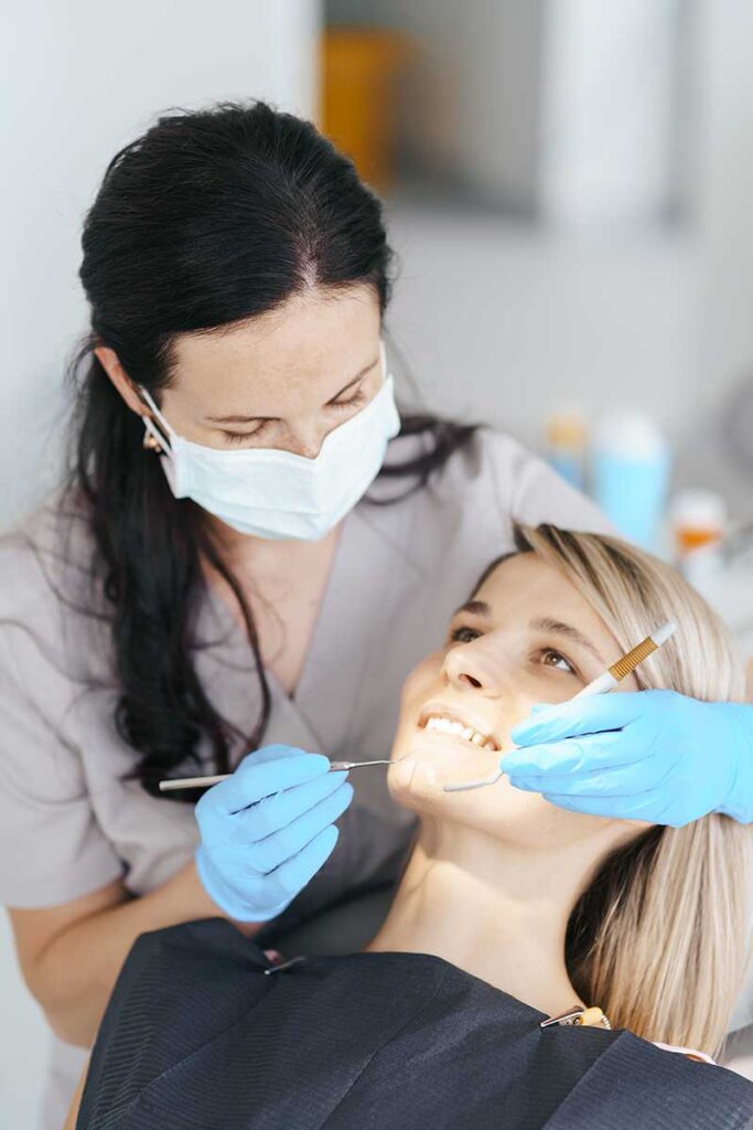 dentist checking the dental bonding procedure results on one of her patients