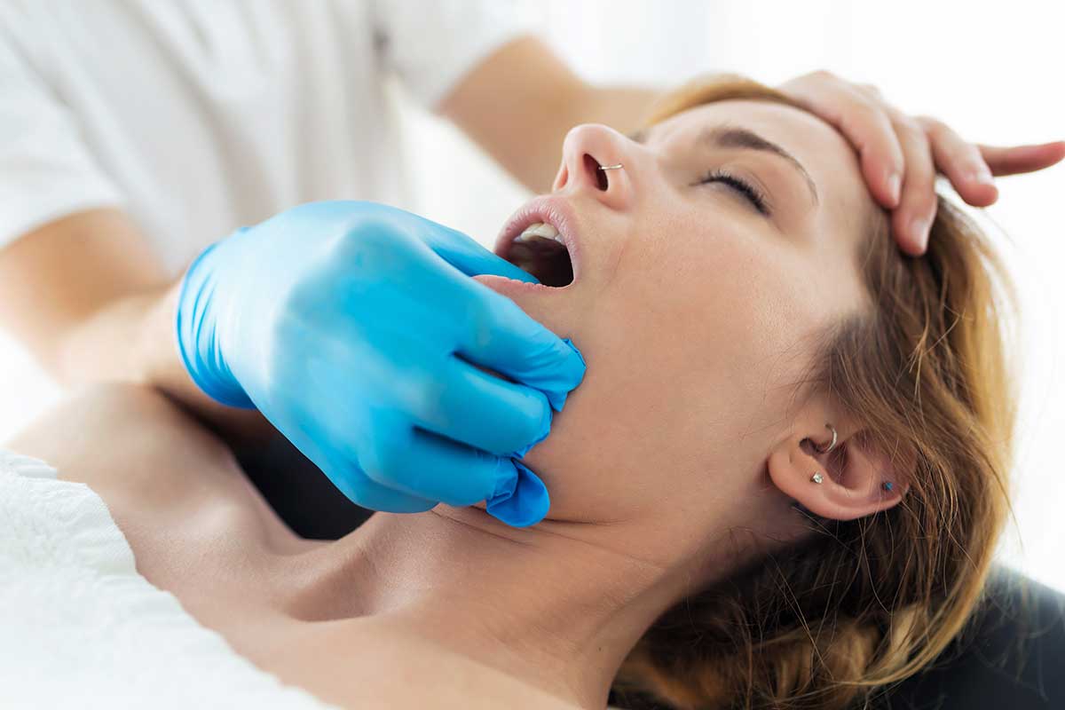 woman is getting a massage to help alleviate her jaw pain