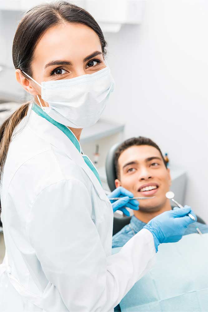 oral surgeon and her patient smile back at the camera