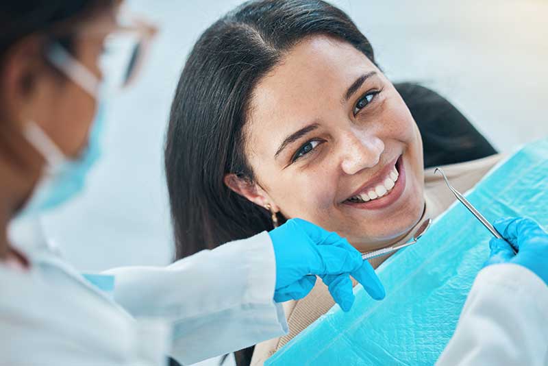 woman smiling because she knows oral reconstructive surgery is going to fix her smile