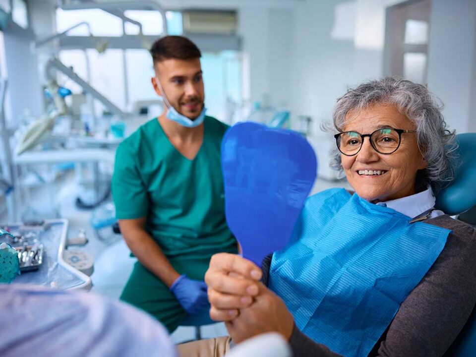 Elderly woman smiling because she had asked how much does dental care cost with CDCP so she knows that she's fully covered for her treatment
