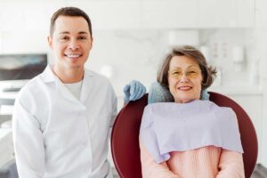 senior woman smiles while sitting beside her dentist after he explained about CDCP eligibility