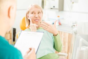 woman complaining about tooth pain and asking her dentist questions about the cDCP