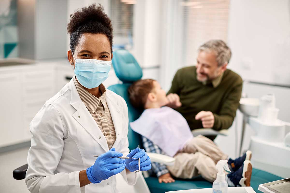 child in the dentists chair while dentist looks confident that CDCP coverage is right for them