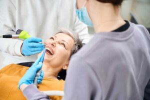 elderly woman in the dentists chair getting treatment handling a dental emergency using CDCP coverage