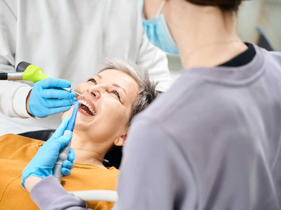 elderly woman in the dentists chair getting treatment handling a dental emergency using CDCP coverage