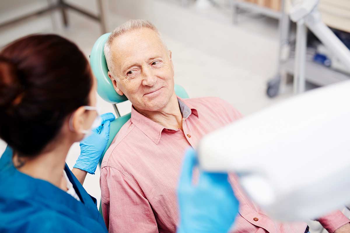 man look spleased while sitting in the dentist chair finally getting a routine checkup thanks to the CDCP