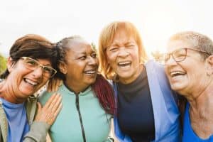 a group of diverse senior canadians laughing and emphasizing why the canadian dental care plan is so important