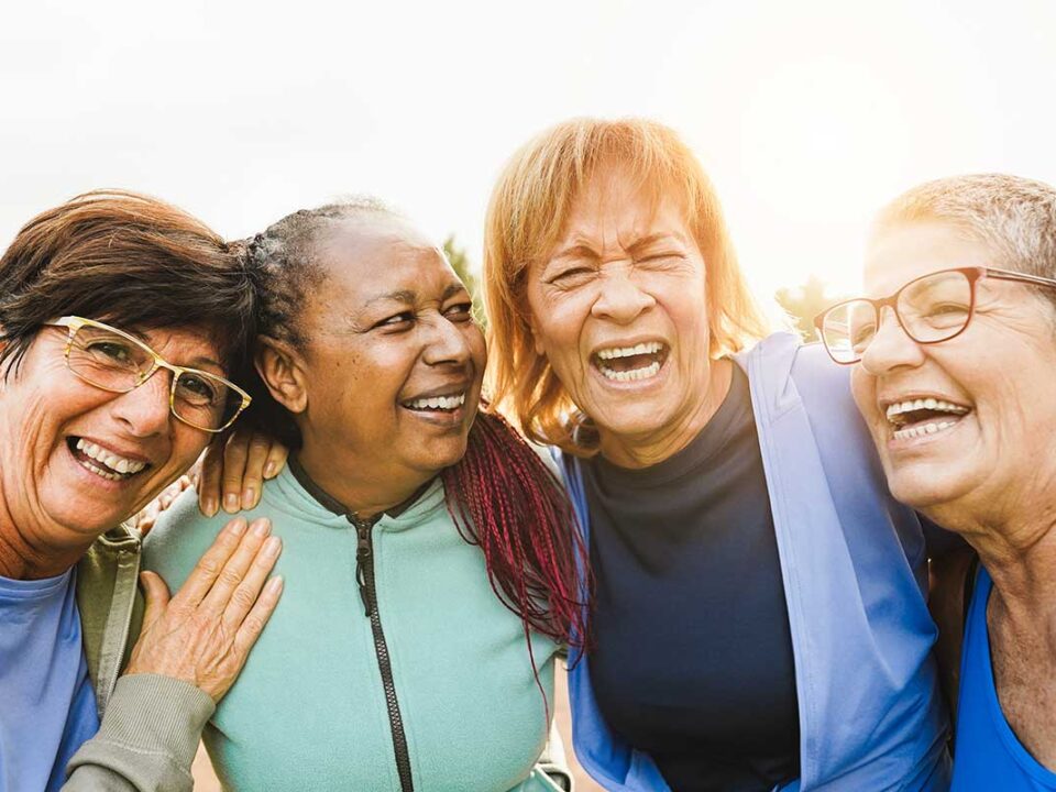 a group of diverse senior canadians laughing and emphasizing why the canadian dental care plan is so important