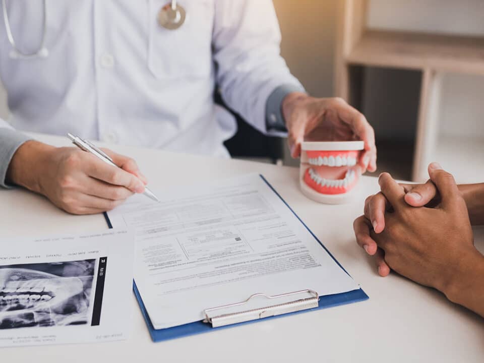 dentist sitting with patient at a desk Navigating the CDCP Claim Process