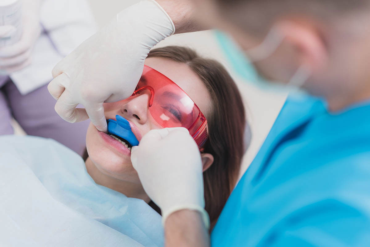 teenage girl in the dentist chair having a fluoride treatment applied to her teeth