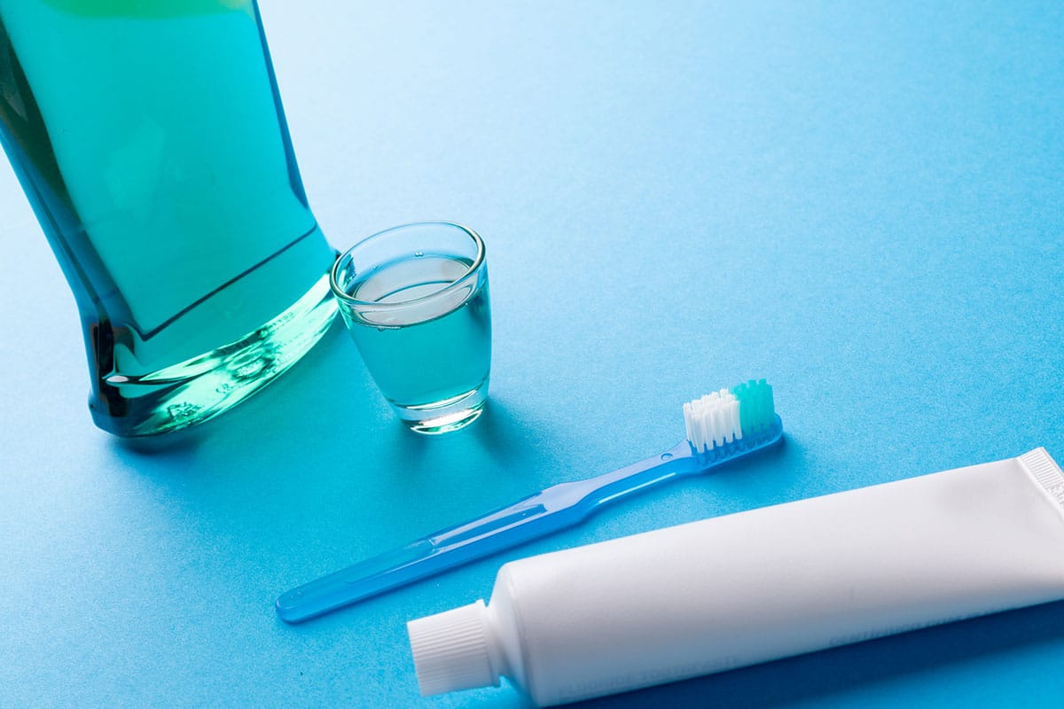 photo of fluoride rinse and toothpaste on a blue background