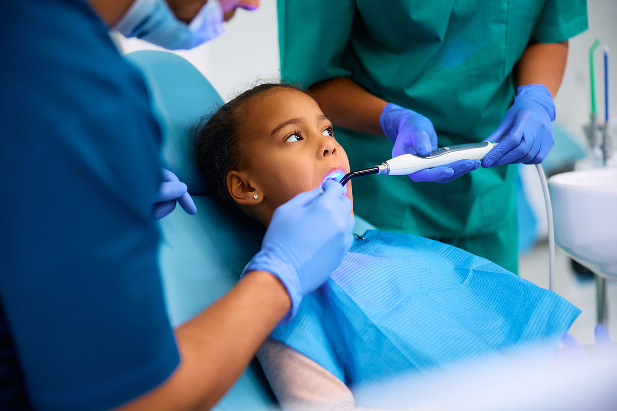 young black girl at the dentist having a cavity repaired