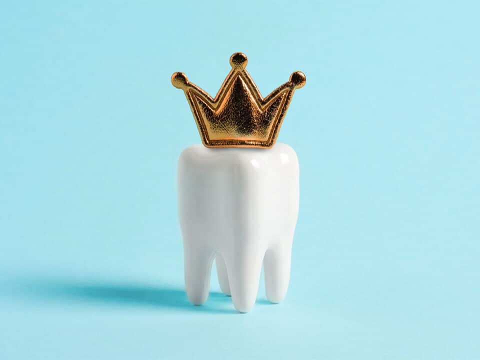 image of a dental crown (tooth shape, wearing a golden crown on top of it