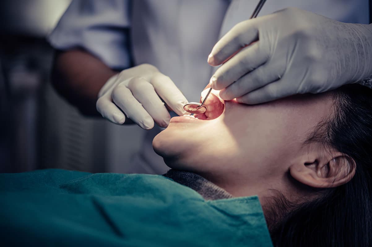 patient at the dentists office getting a oral cancer screening as part of their dental checkup