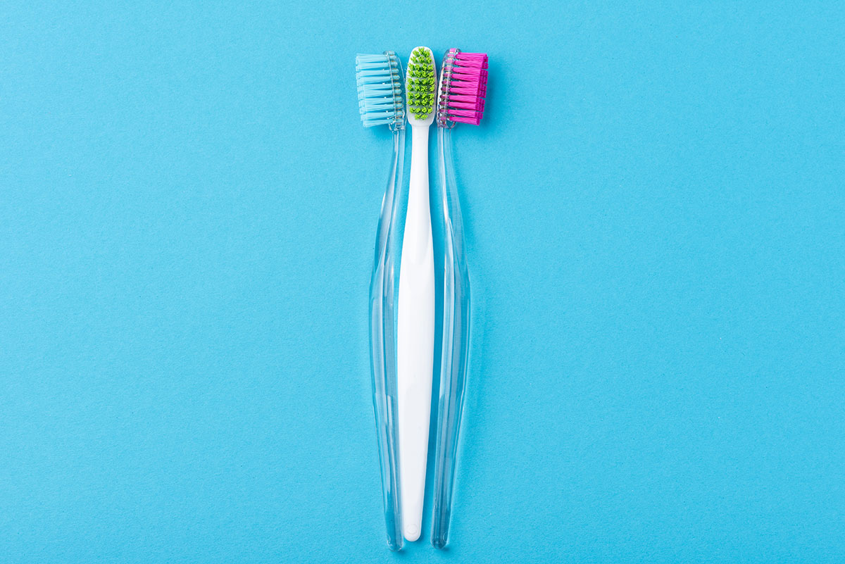 image of two toothbrushes on blue background