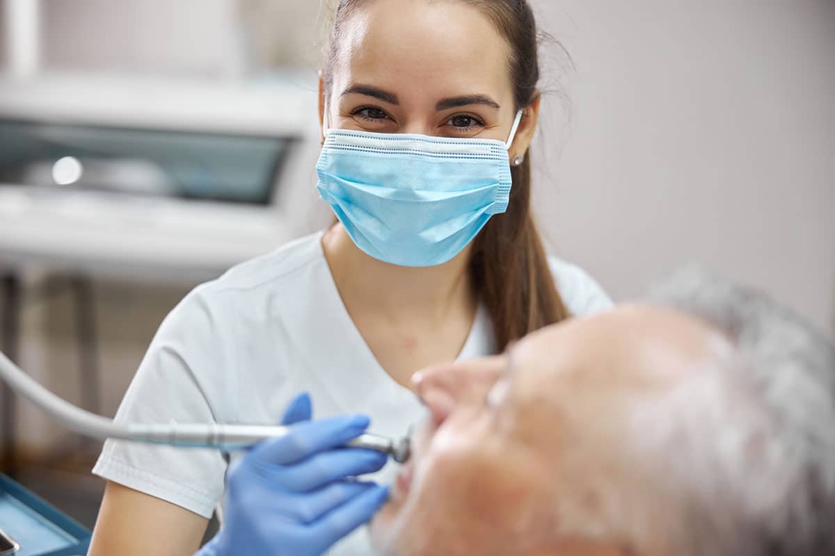 female dentist with a facemask on can help with dry mouth treatments