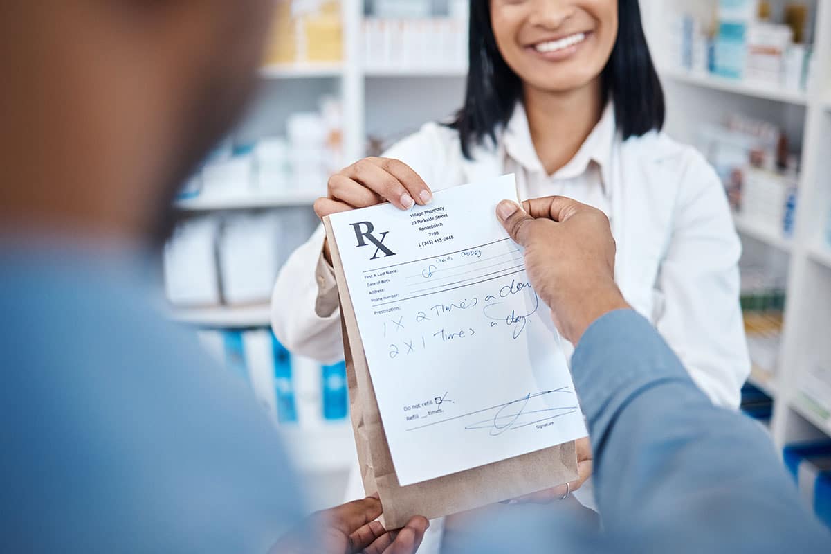 female pharmacist is handing over a prescription for dry mouth medication