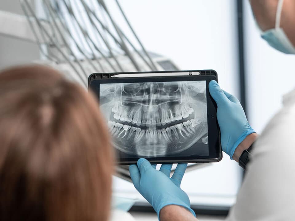 dentist is going over dental x-rays with a patient who asked how often should i get dental x-rays