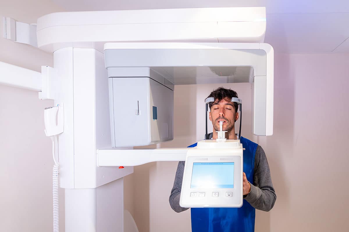 man having his dental imaging done with a modern dental x-ray machine