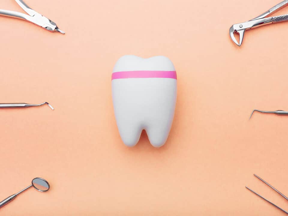 image of a tooth surrounded by dental tools, used in the process of how dentists evaluate enamel health