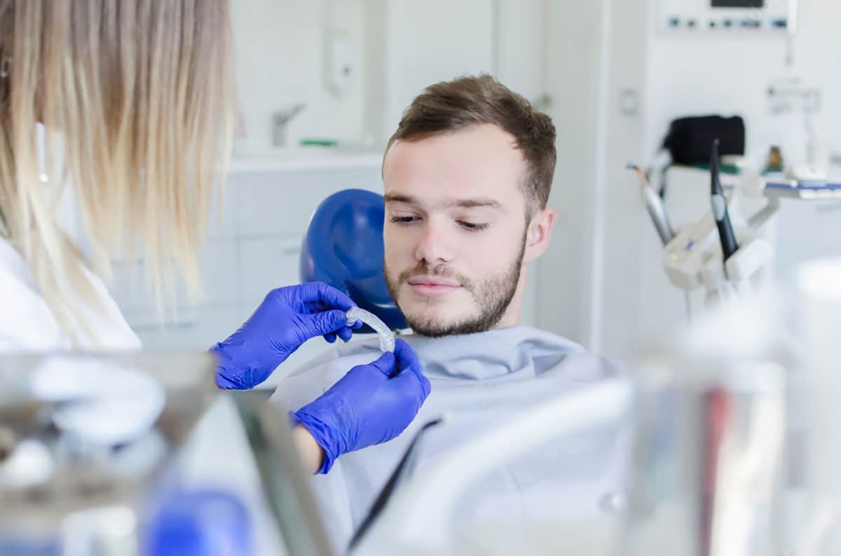 man is having professional teeth whitening done in clinic, making the best choice for his teeth