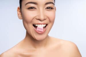 woman enjoys chewing her xylitol gum as a sugar substitute and oral health enhancer