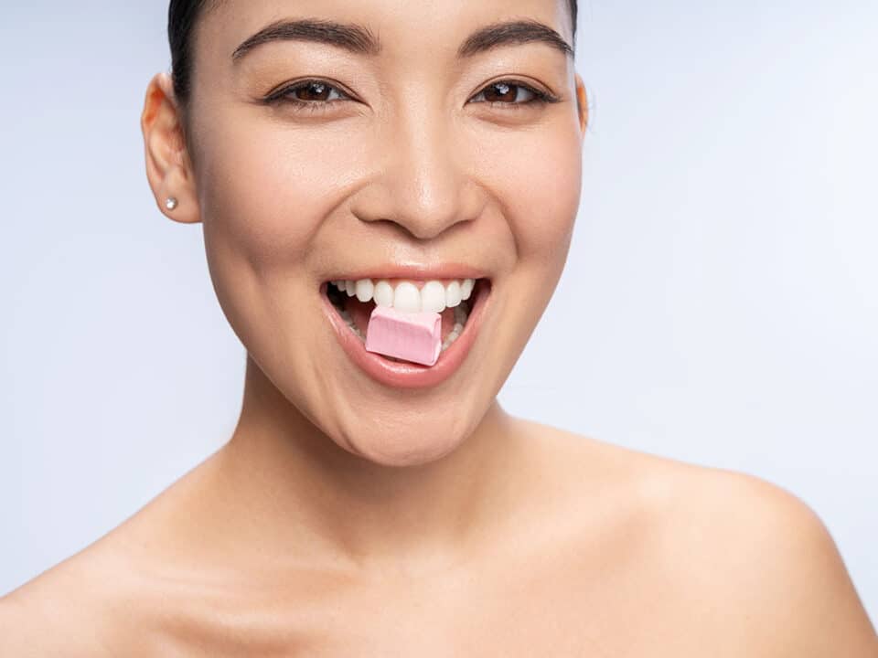 woman enjoys chewing her xylitol gum as a sugar substitute and oral health enhancer