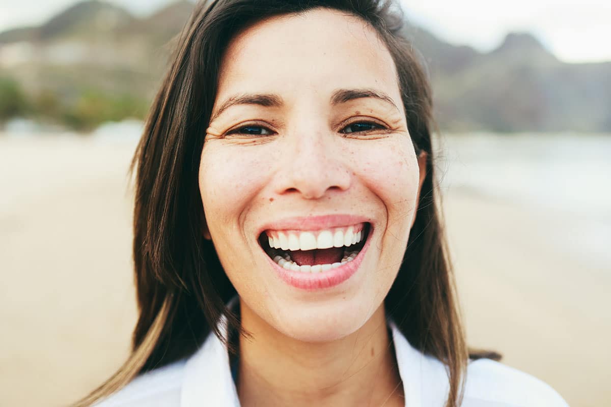 woman smiling showing off very white teeth thanks to an in-office whitening