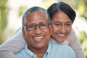 happy elderly couple smiling after finding out the affordable cost of dental implants in hamilton
