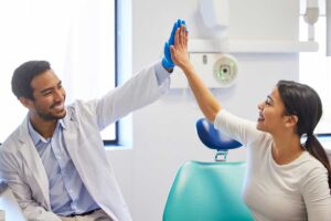 woman patient hi-fives her dentist because she's so happy she managed to find a hamilton dentist accepting new patients