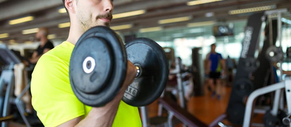 man doing a bicep curl after asking his dentist How long should you wait to exercise after tooth extraction?