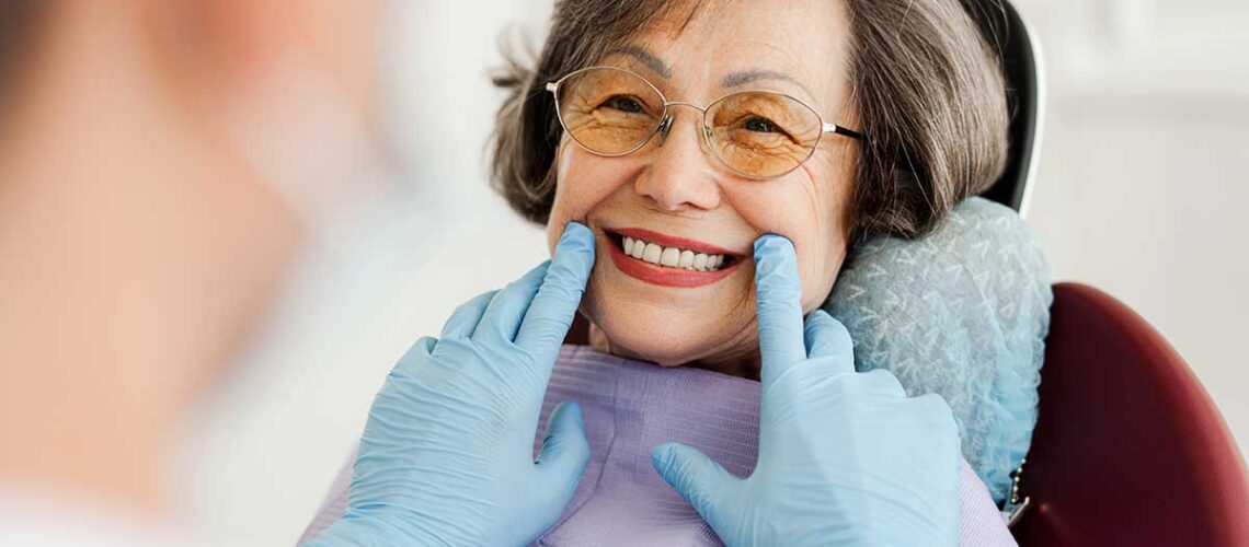 smiling asian woman at the dentists office after successfully applying to the CDCP