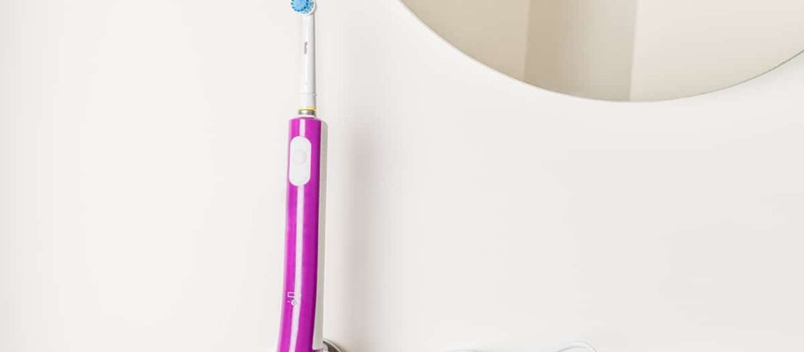 photo of an electric toothbrush standing in the bathroom