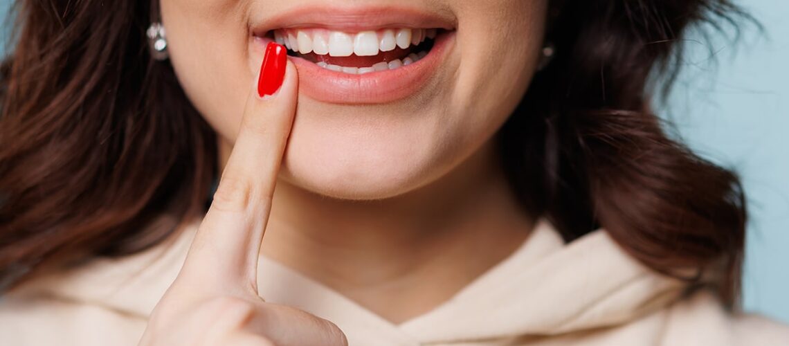 woman pointing to her amazing smile she got from a cosmetic dentist