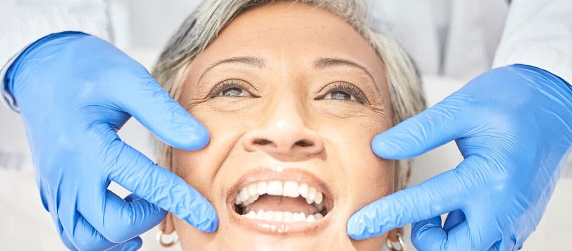 older woman smiling as she receives dental care for elderly denture wearers