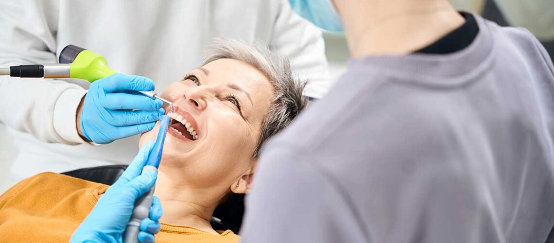 elderly woman in the dentists chair getting treatment handling a dental emergency using CDCP coverage